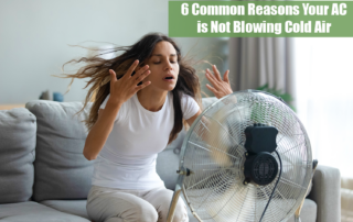 A woman in a white tshirt and long brown hair sitting on a gray couch in front of a fan because her AC is not blowing cold air.