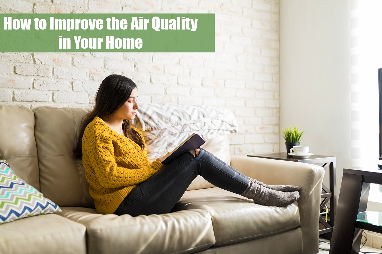 A woman sitting on a beige couch reading a book in a room with great indoor air quality.